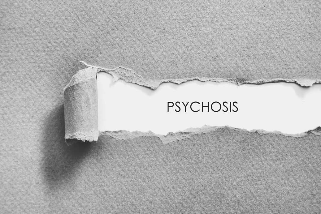 Psychosis word written under torn paper.